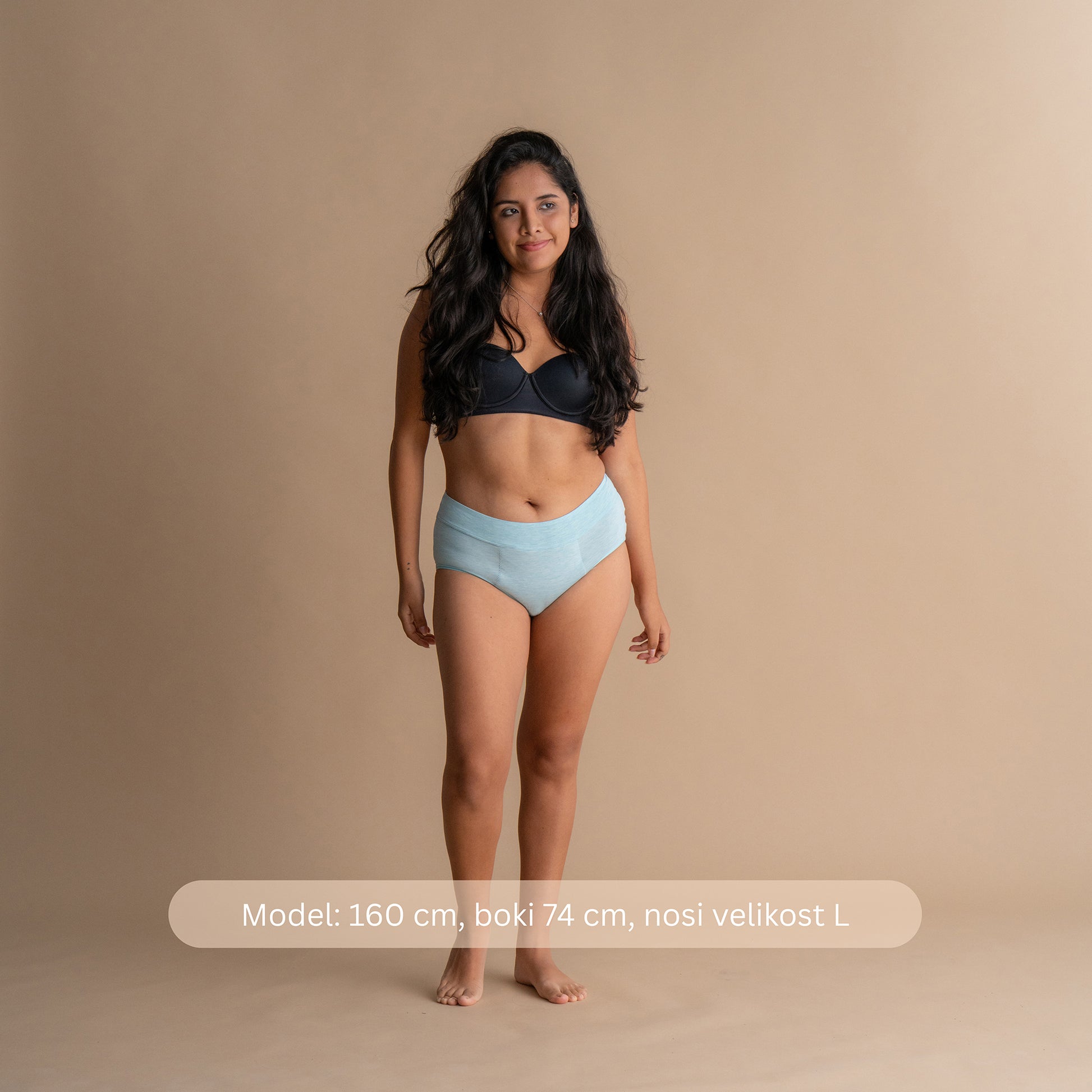 Model višine 160 cm z boki 74 cm nosi velikost L svetlo modrih Floena Leakproof Bamboo High Waist Brief, visoko pasne menstrualne hlačke, z navedbo mere