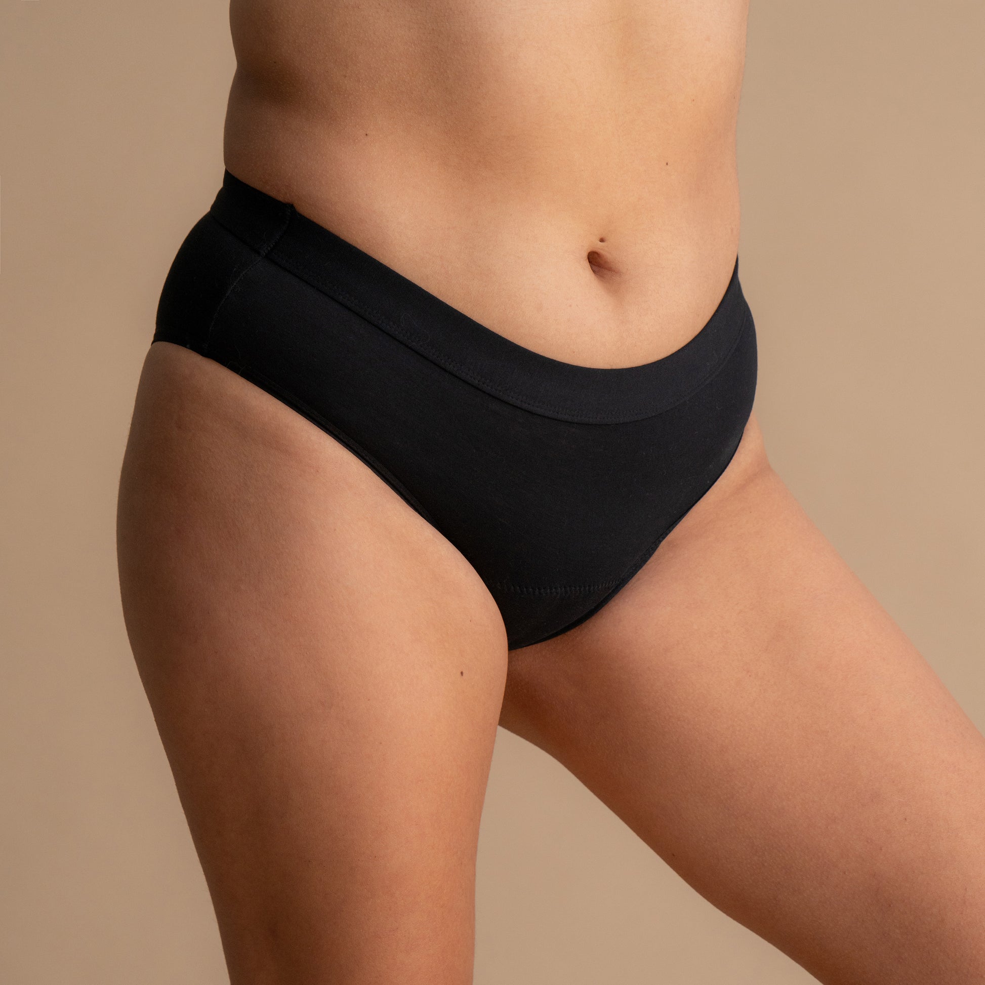 Celoten stranski pogled na model v črni Floena Leakproof Everyday Bamboo Bikini, bambusove menstrualne hlačke, z gladkim pasom
